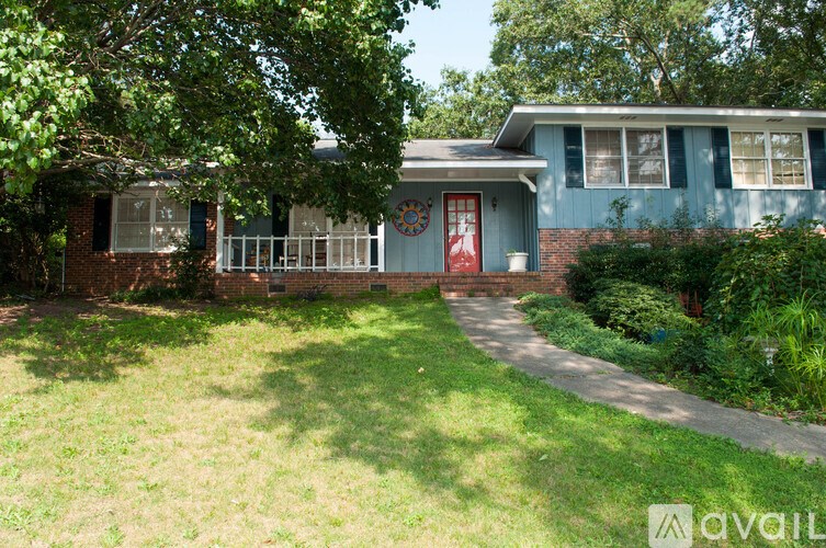 A house with a red door and a green lawn.