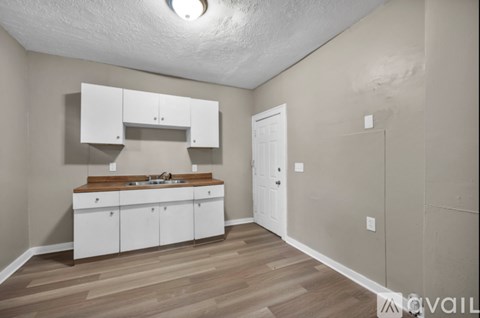 A kitchen with white cabinets and a wooden countertop.