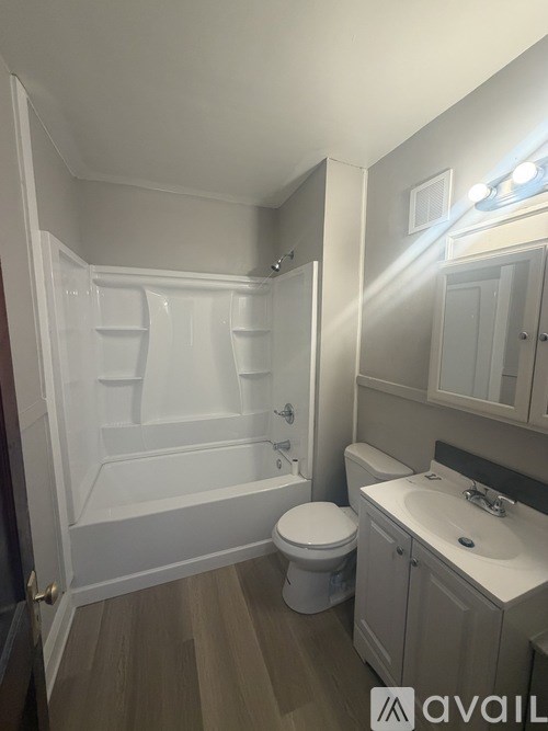 A bathroom with a toilet, sink, and bathtub.