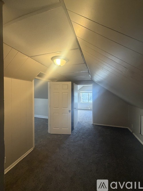 A room with a carpeted floor and a door in the middle.