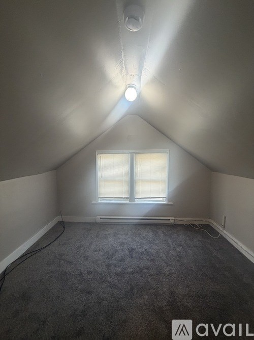 A room with a window and a light on the ceiling.