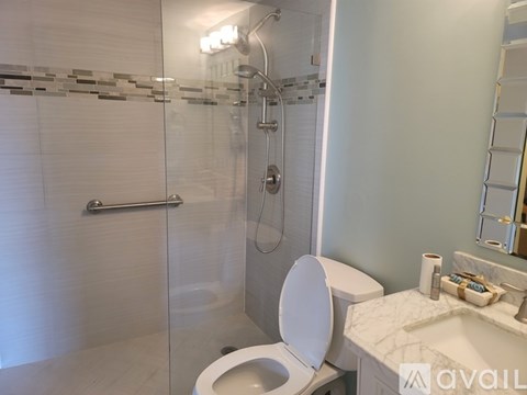 A white toilet in a bathroom with a glass shower door.