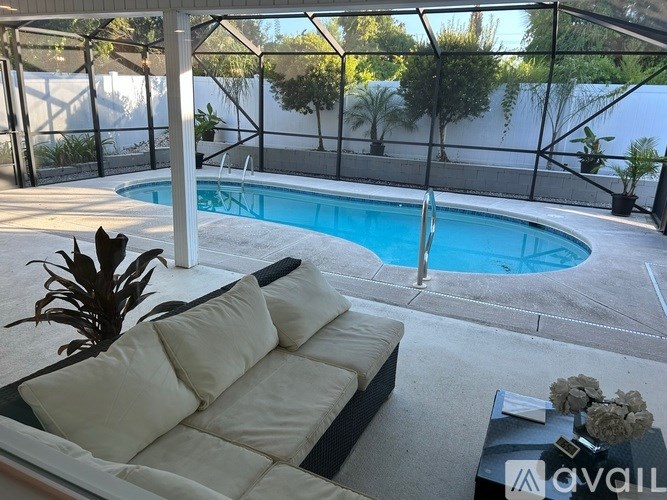 A modern outdoor living space with a pool and a comfortable couch.