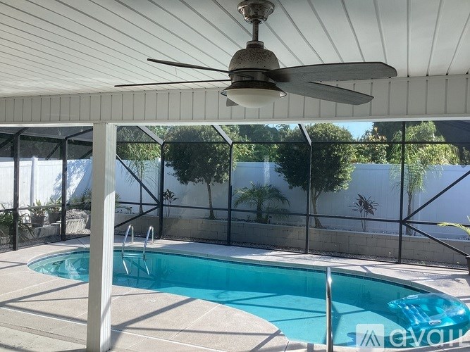 A pool with a ceiling fan in a sunny backyard.