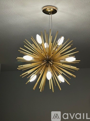 A large, gold chandelier with multiple lights hanging from the ceiling.