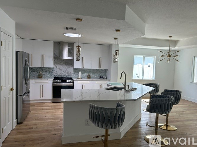 A kitchen with a marble countertop and bar stools.