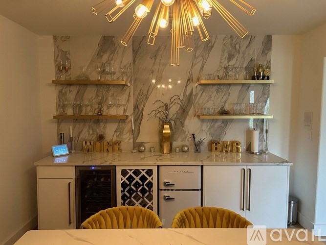 A modern kitchen with a marble backsplash and a bar area.