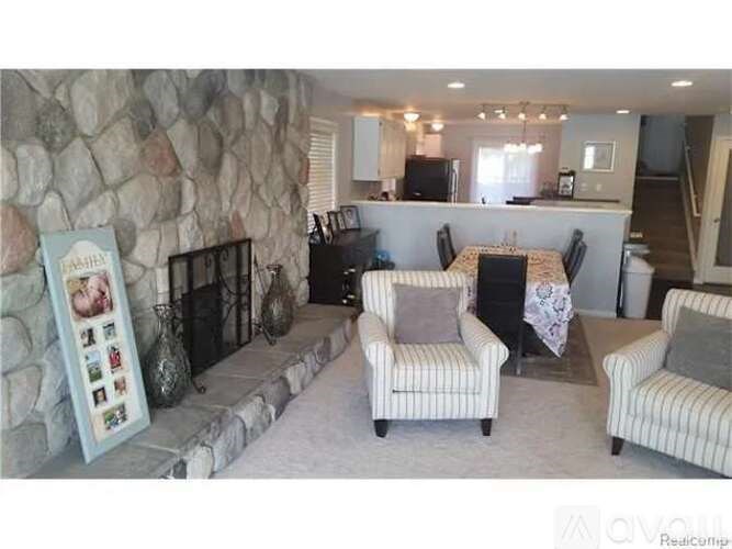 A living room with a stone wall and a framed picture of a family.