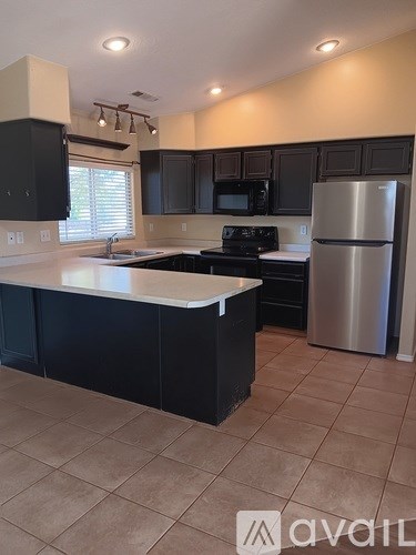 A kitchen with black cabinets and a white countertop.