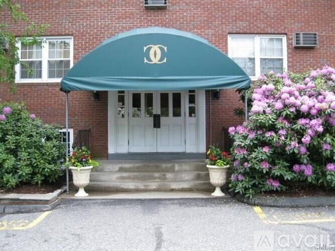 A building with a green awning and a white door.