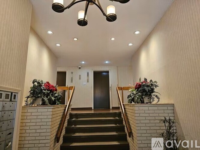 A staircase with a black railing and a wooden handrail with a light fixture above it.