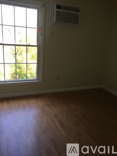 A room with a window and wooden flooring.