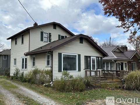 A house with a brown roof and a grey wall is shown.
