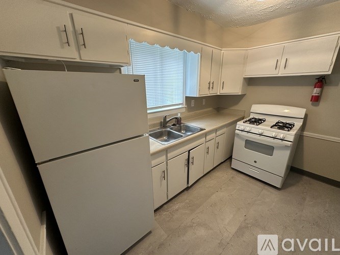 A small kitchen with white appliances and cabinets.