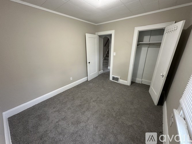 A room with a grey carpet and white walls.
