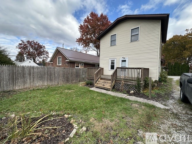 A house with a wooden fence and a small garden in front.