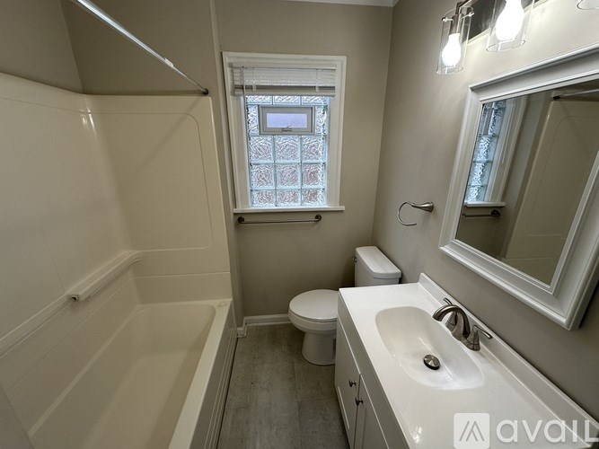A bathroom with a toilet, sink, and bathtub.