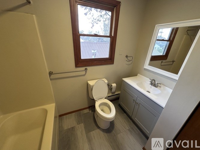 A bathroom with a toilet, sink, and tub.