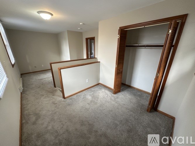 A room with a carpeted floor and a large mirror on the wall.