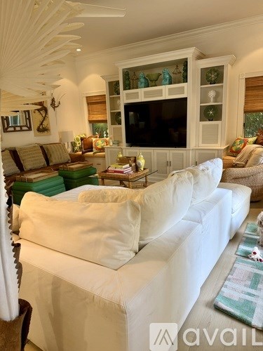 A living room with a white couch and a television.