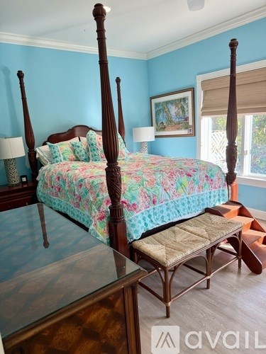 A silver car is parked in front of a yellow house.