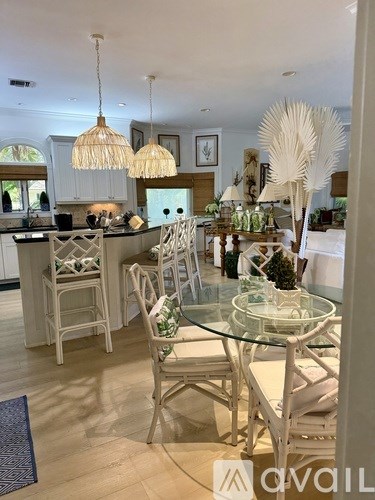 A white dining room with a glass table and chairs.