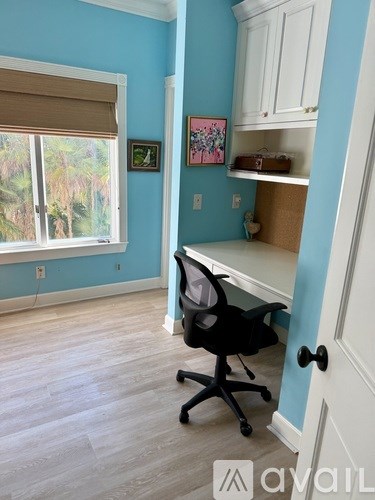 A room with a blue wall and a black office chair.
