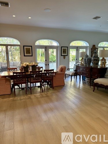 A dining room with a wooden table and chairs.