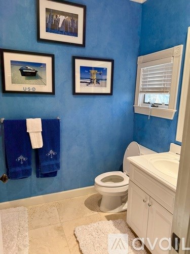 A bathroom with blue walls and a white toilet.