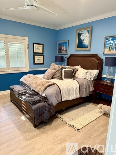 A bedroom with a large bed and a ceiling fan.