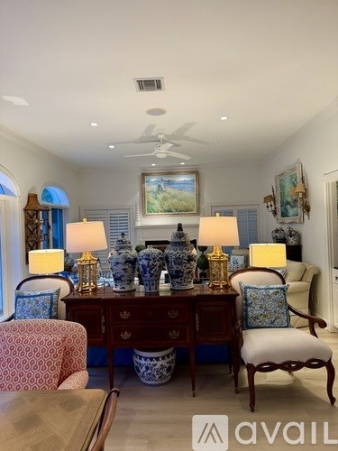 A room with a table, chairs, and a painting on the wall.