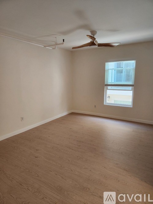 A room with a ceiling fan and a window.
