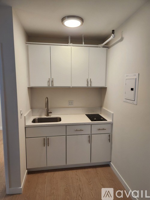 A kitchen with white cabinets and a sink.