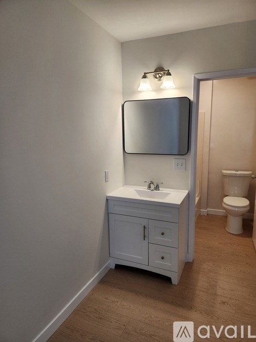 A bathroom with a white cabinet and a mirror above the sink.