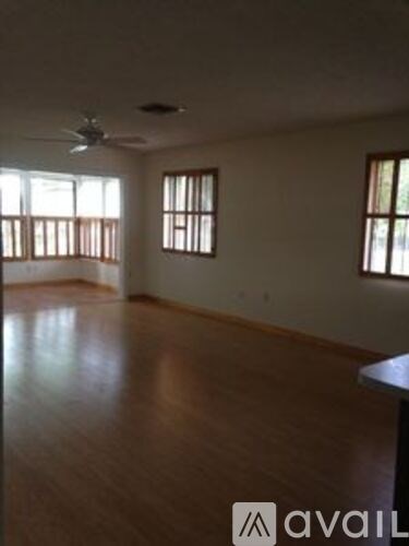 A room with wooden floors and a ceiling fan.