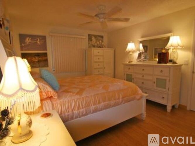 A bedroom with a bed, dresser, and mirror.