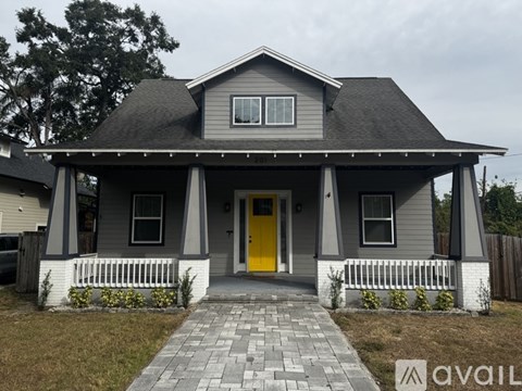 A house with a yellow door and a grey roof.