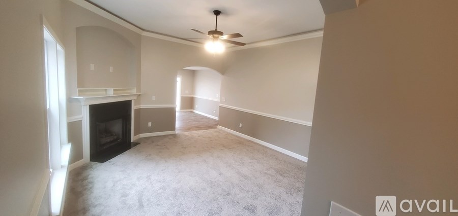 A living room with a fireplace and a ceiling fan.