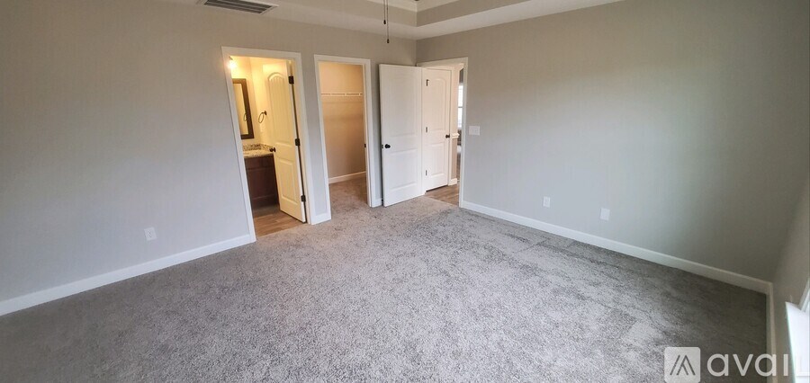 A room with carpeted floor and two open doors.