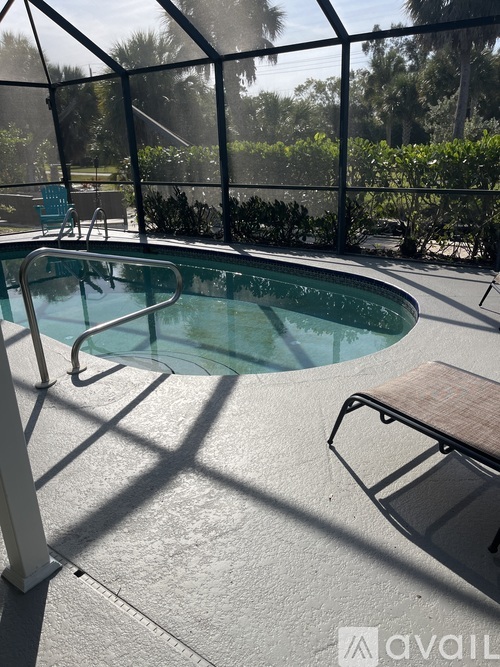 A hot tub sits in the middle of a patio surrounded by a fence.
