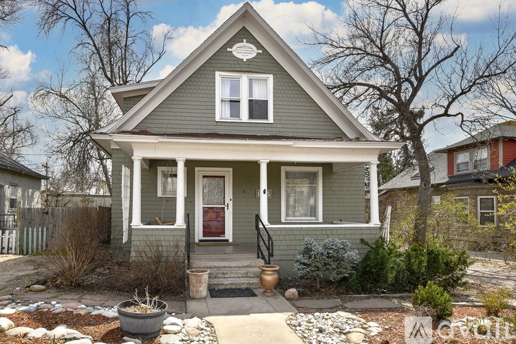 A small house with a red door and a front porch.
