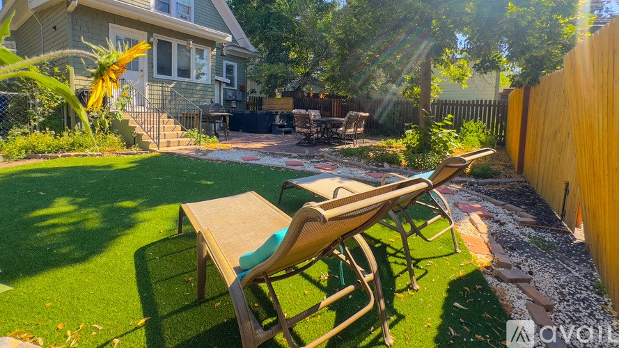 A backyard with a wooden fence and a green lawn.