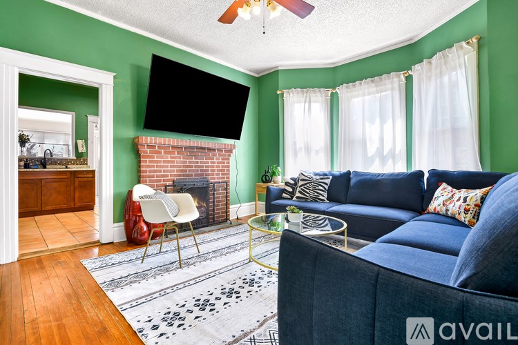 A living room with a blue couch and a fireplace.