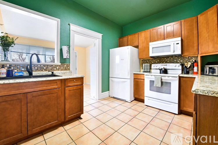 A kitchen with white appliances and brown cabinets.