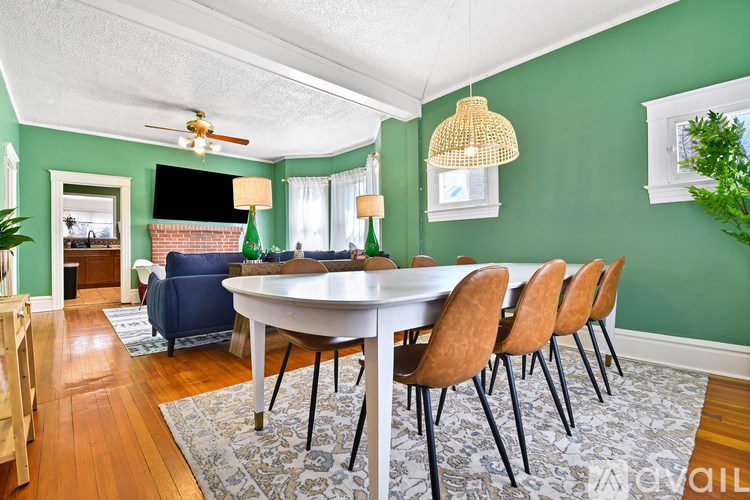 A dining room with a white table and chairs.