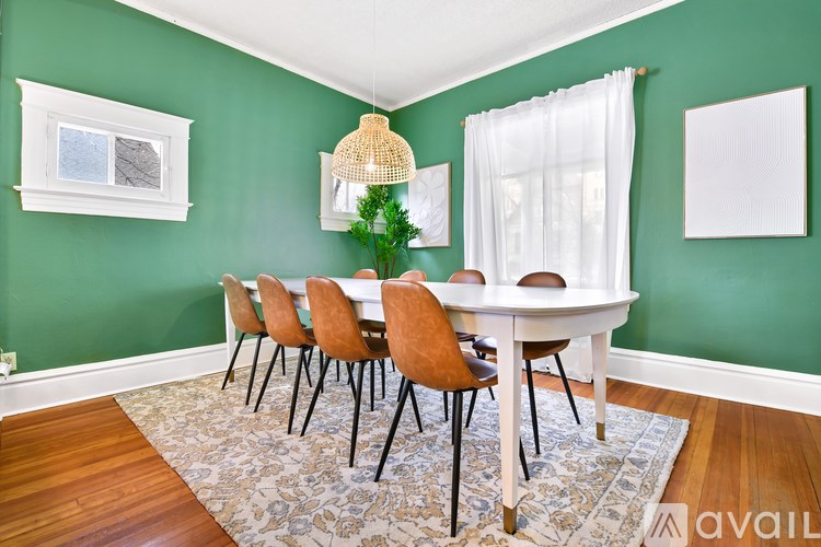A dining room with green walls and a white table.