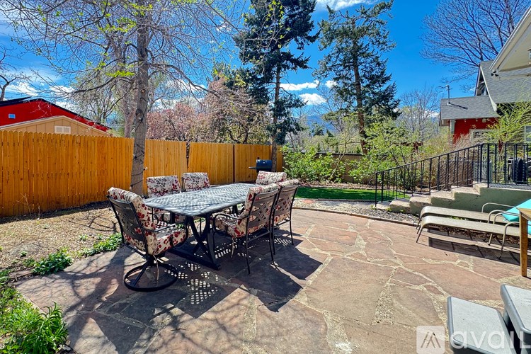 A backyard with a table and chairs.
