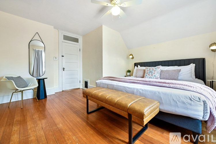 A bedroom with a bed, bench, and chair.