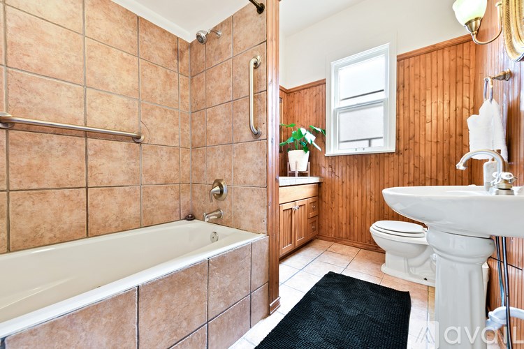 A bathroom with a tub, toilet, and sink.