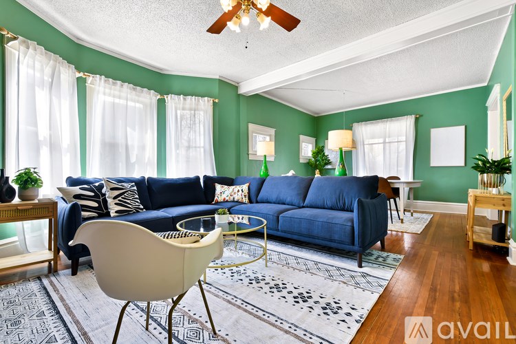 A living room with a blue couch and a white chair.